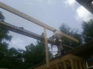 Carpenter setting a ridge beam over a new addition frame — Ice Dam Removal by Roofing Brothers in Armour