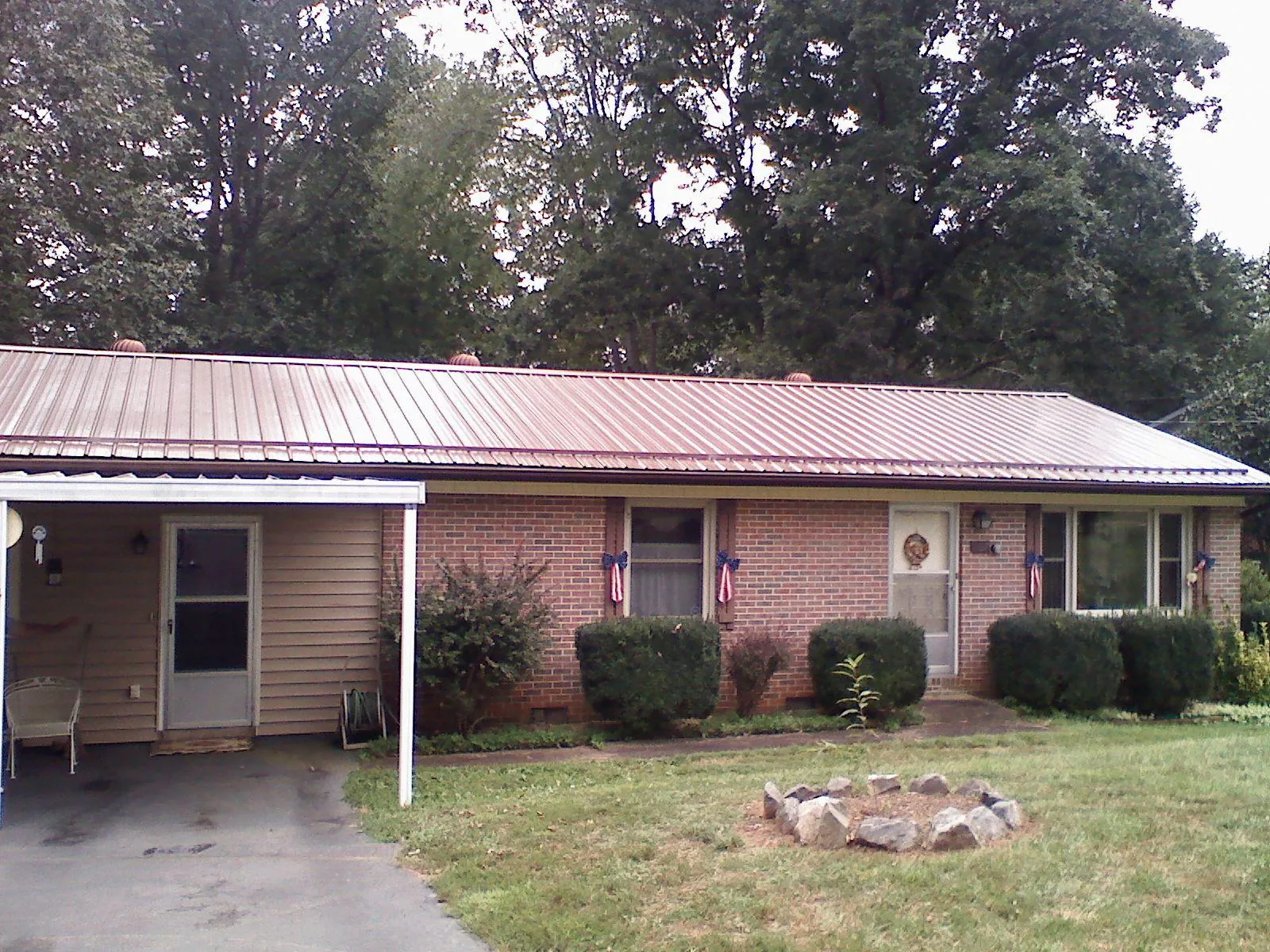 Bronze metal roof and carport on a brick ranch home — Roof Repair work by our crew in Armour